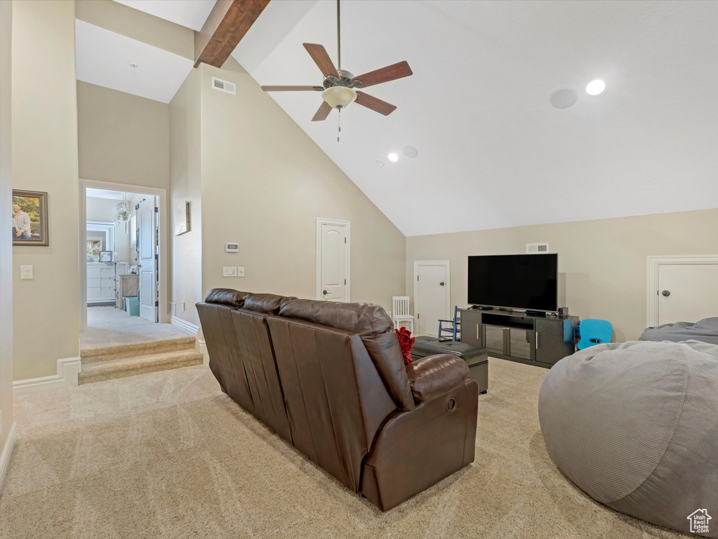 Living room featuring visible vents, baseboards, high vaulted ceiling, beamed ceiling, and light colored carpet