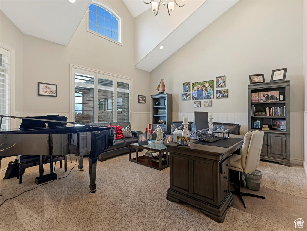 Office featuring a notable chandelier, high vaulted ceiling, carpet flooring, and wainscoting