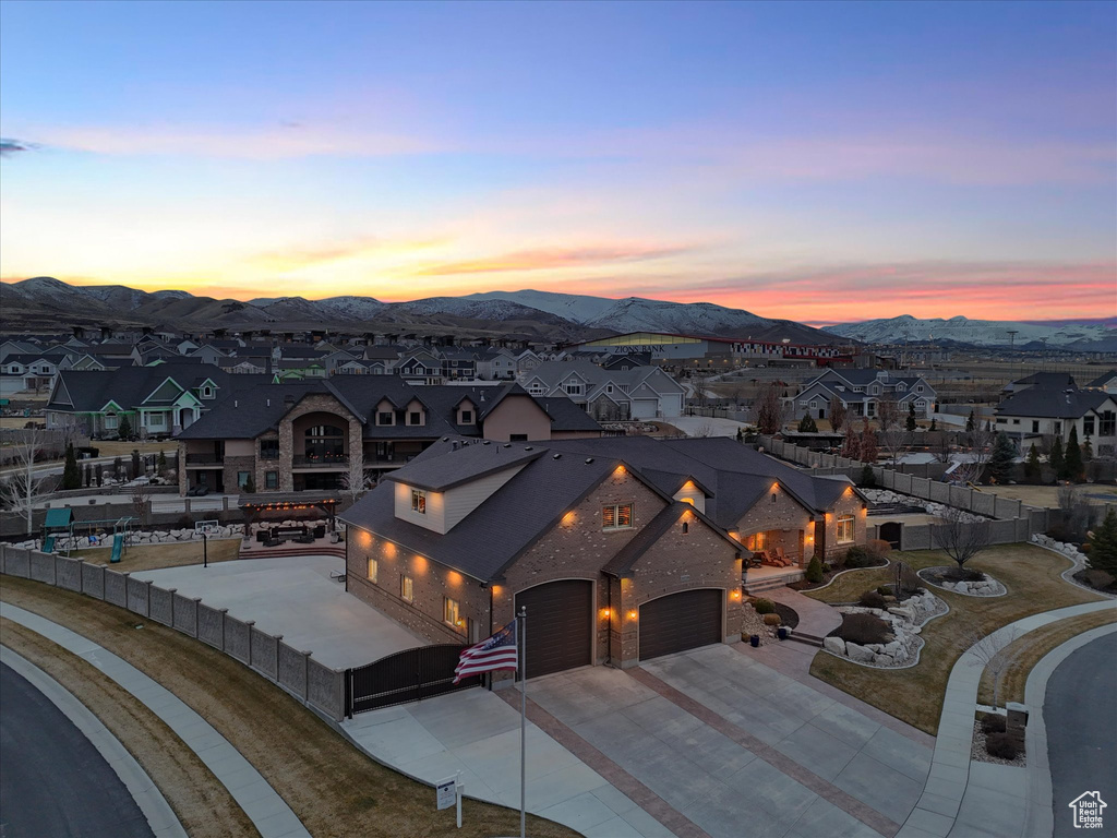 View of front facade featuring fence, a residential view, driveway, a mountain view, and a gate