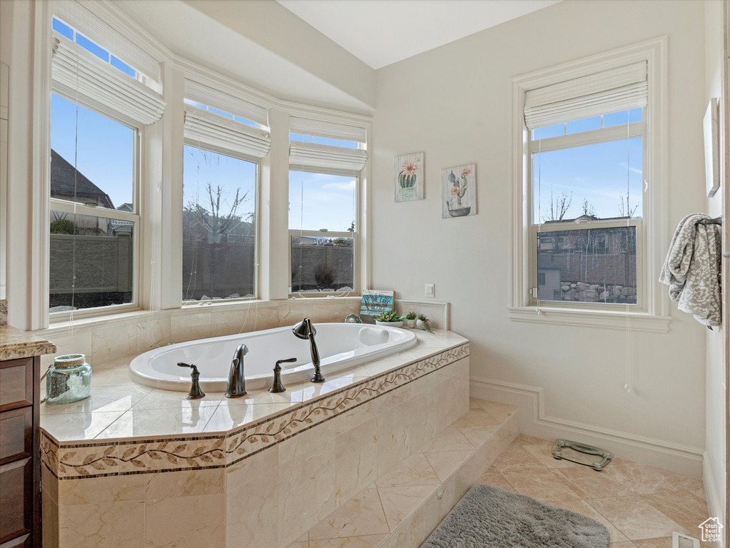 Full bath featuring baseboards, a garden tub, and tile patterned flooring