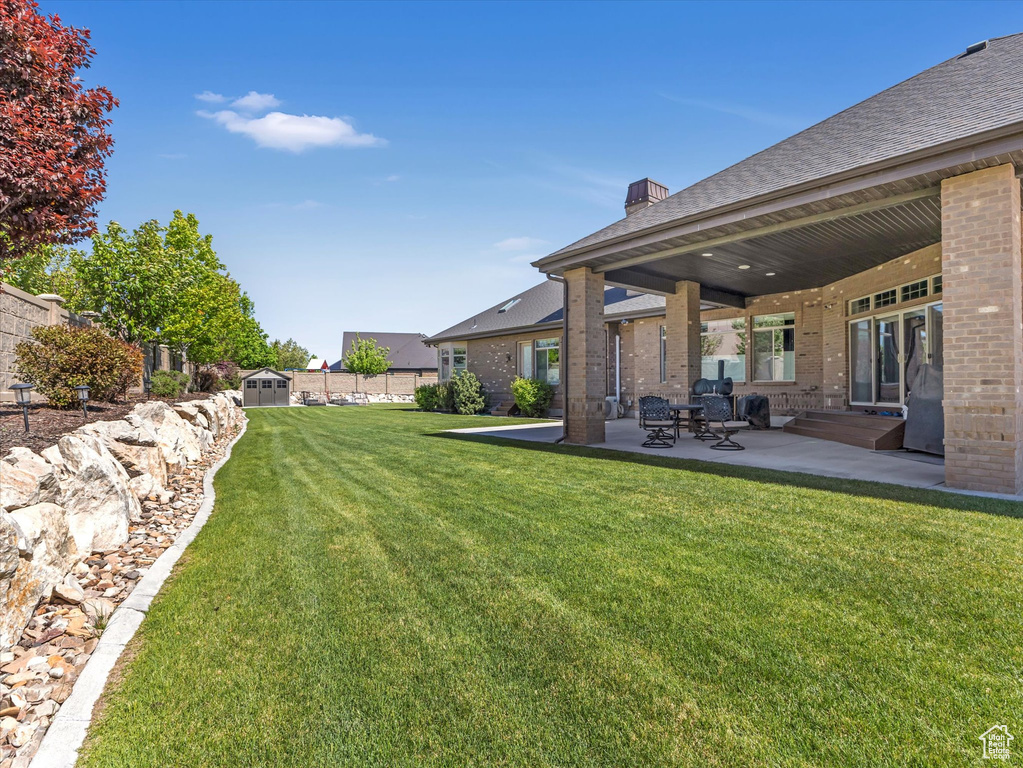 View of yard featuring a patio and a shed