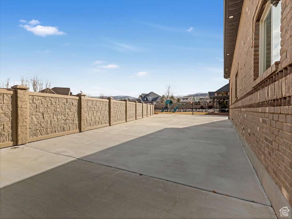 View of patio / terrace featuring a residential view, playground community, and a fenced backyard