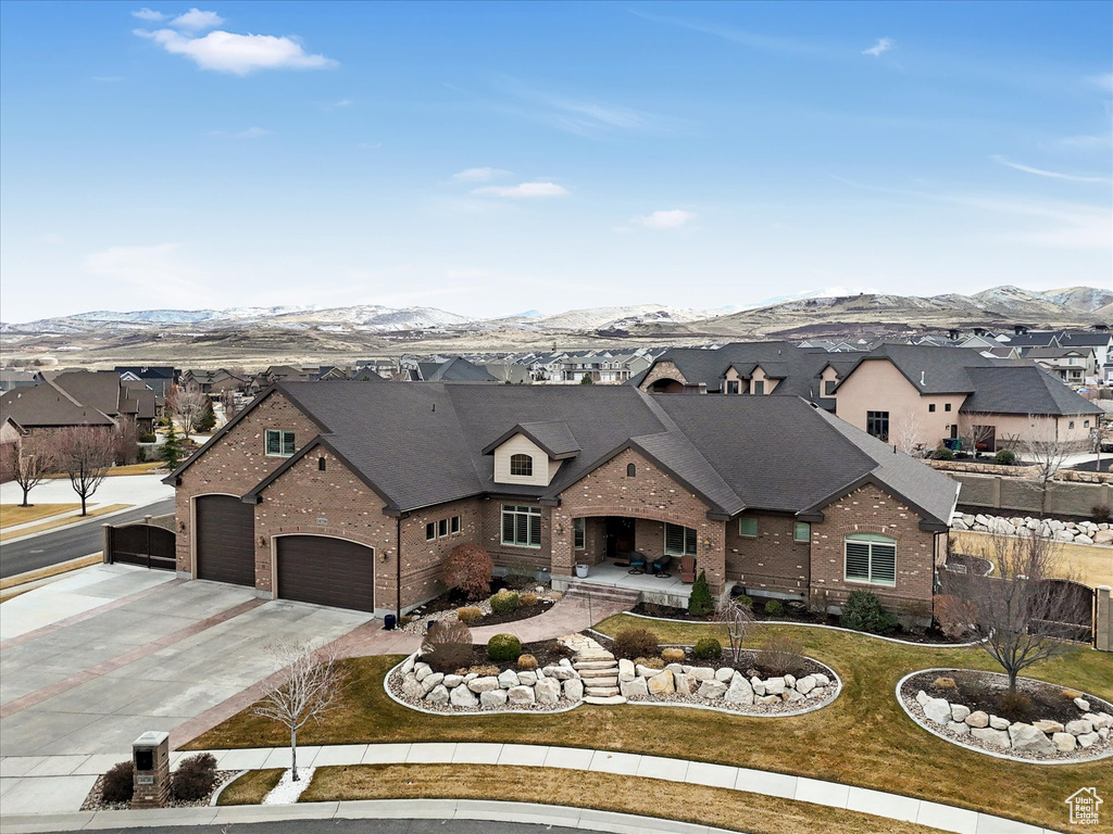 French provincial home with brick siding, a residential view, a mountain view, and driveway