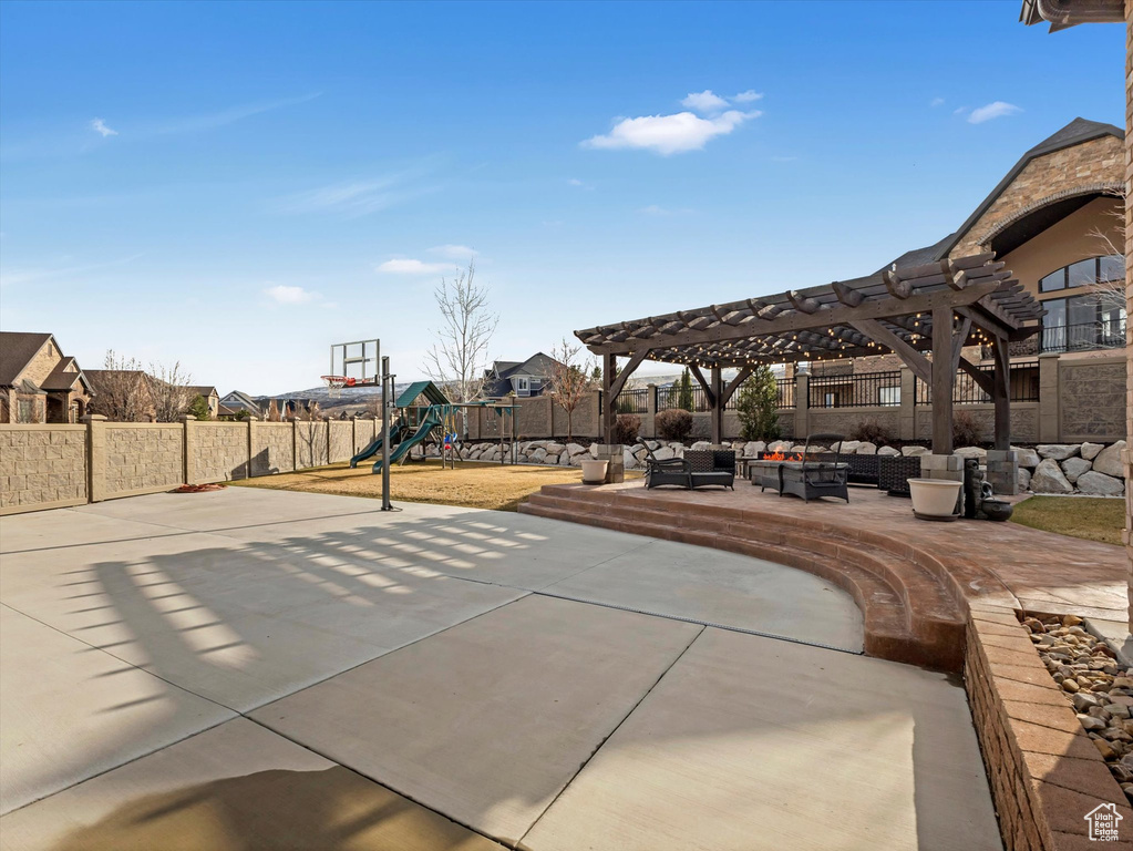 View of patio / terrace featuring playground community, community basketball court, outdoor lounge area, a fenced backyard, and a pergola