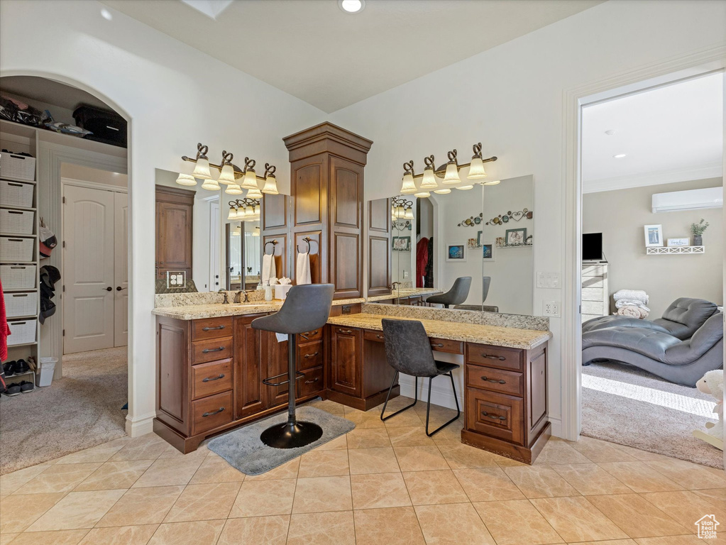 Ensuite bathroom with tile patterned floors, recessed lighting, an AC wall unit, and vanity