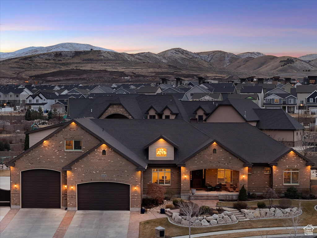 View of front of home featuring brick siding, a residential view, a mountain view, and concrete driveway