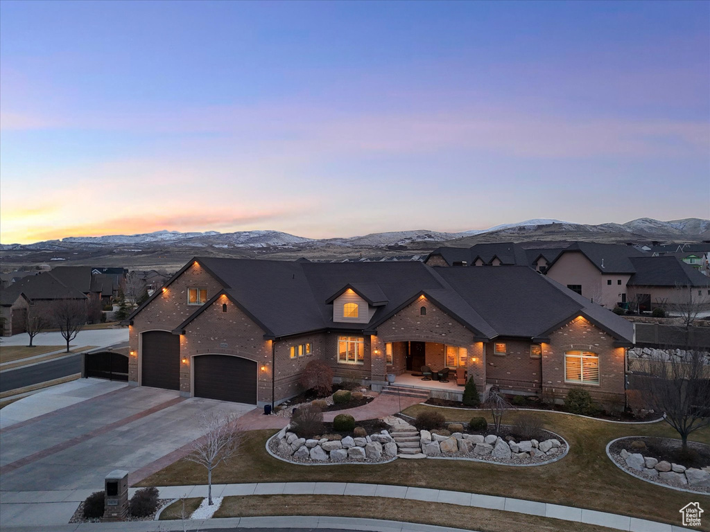 View of front of house featuring a mountain view, a residential view, a garage, and concrete driveway