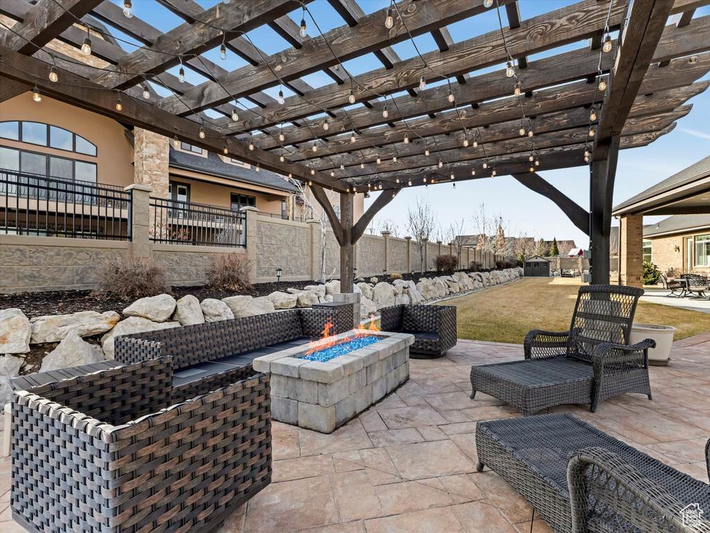 View of patio / terrace with fence, a pergola, and an outdoor fire pit