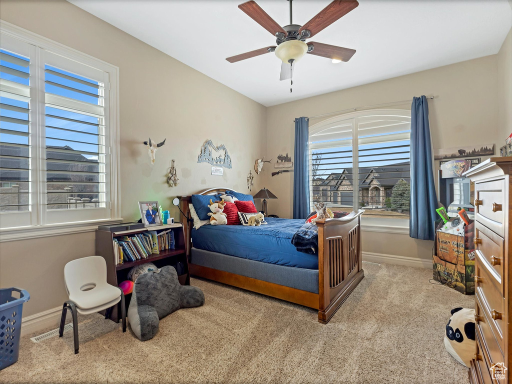 Bedroom with baseboards, carpet floors, and a ceiling fan