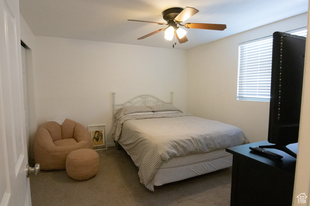 Carpeted bedroom featuring a ceiling fan