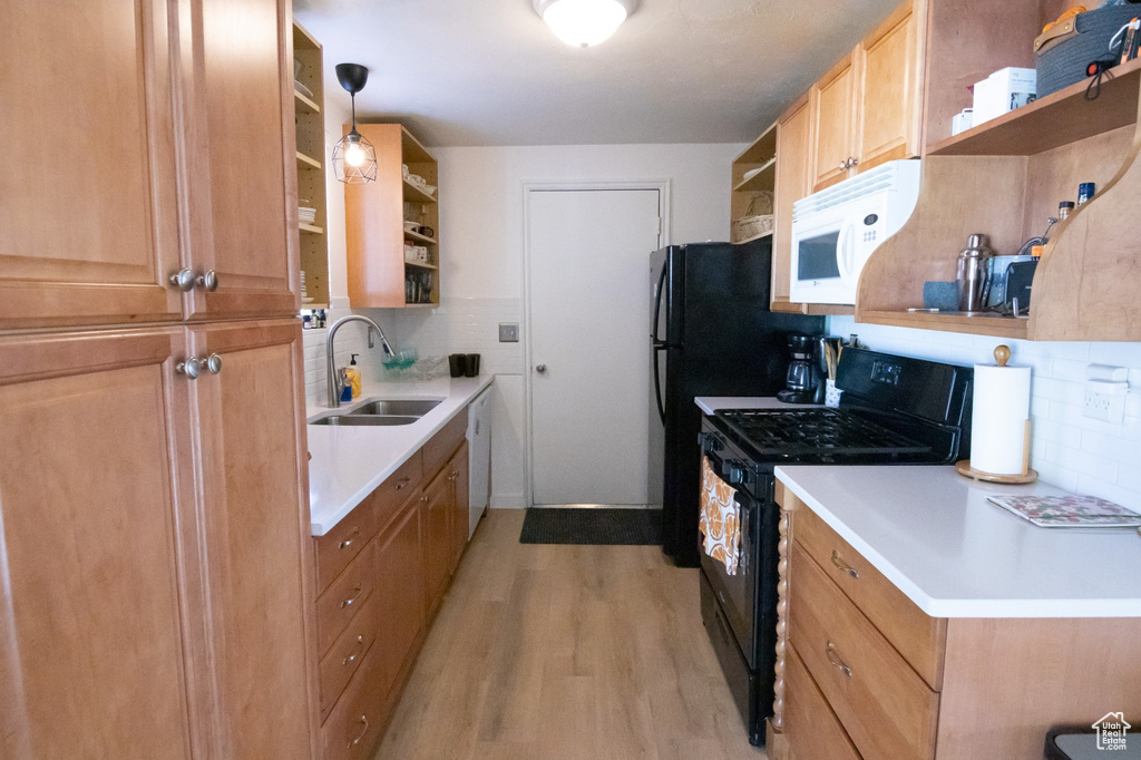 Kitchen featuring white appliances, open shelves, a sink, light wood-type flooring, and backsplash