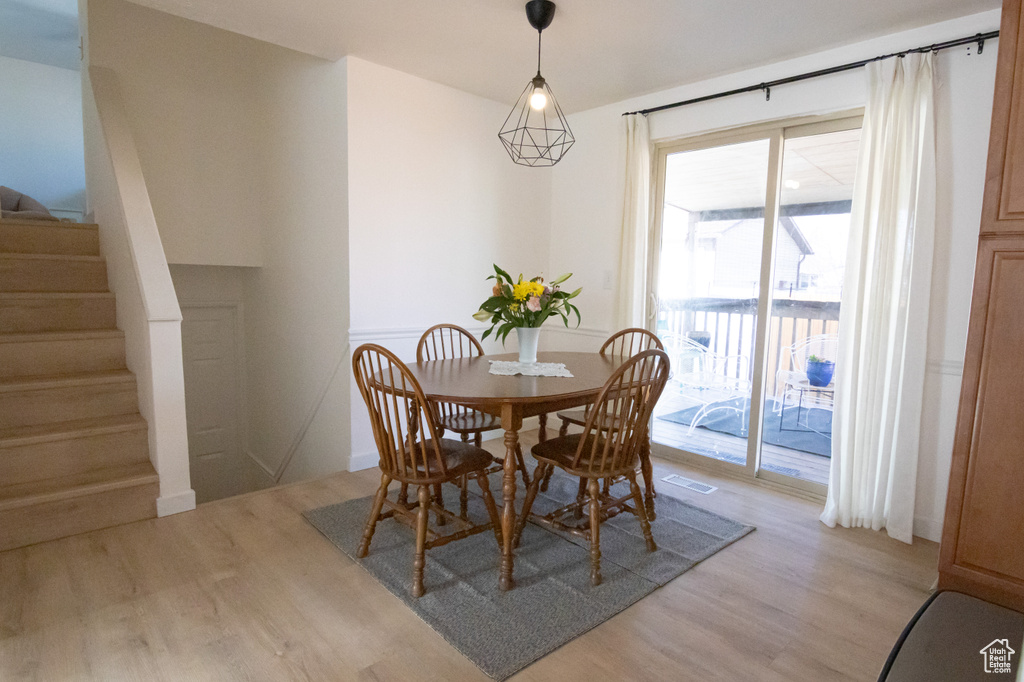 Dining room featuring stairway, visible vents, and light wood finished floors