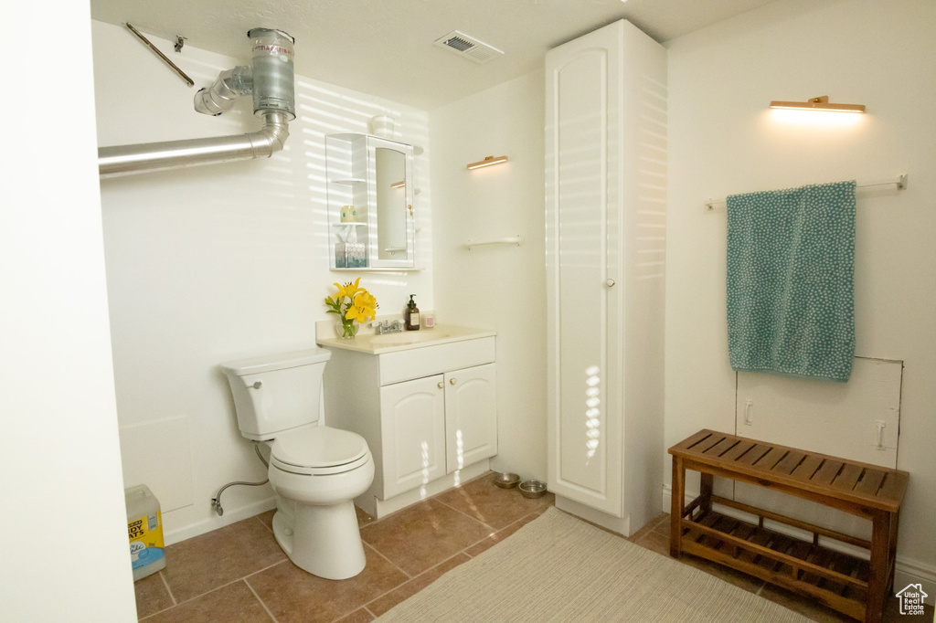 Bathroom with tile patterned flooring, visible vents, toilet, and vanity