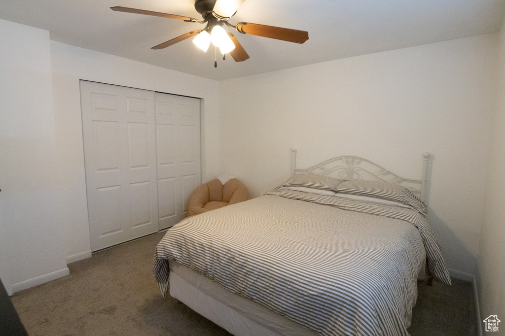 Bedroom with a closet, baseboards, carpet, and a ceiling fan