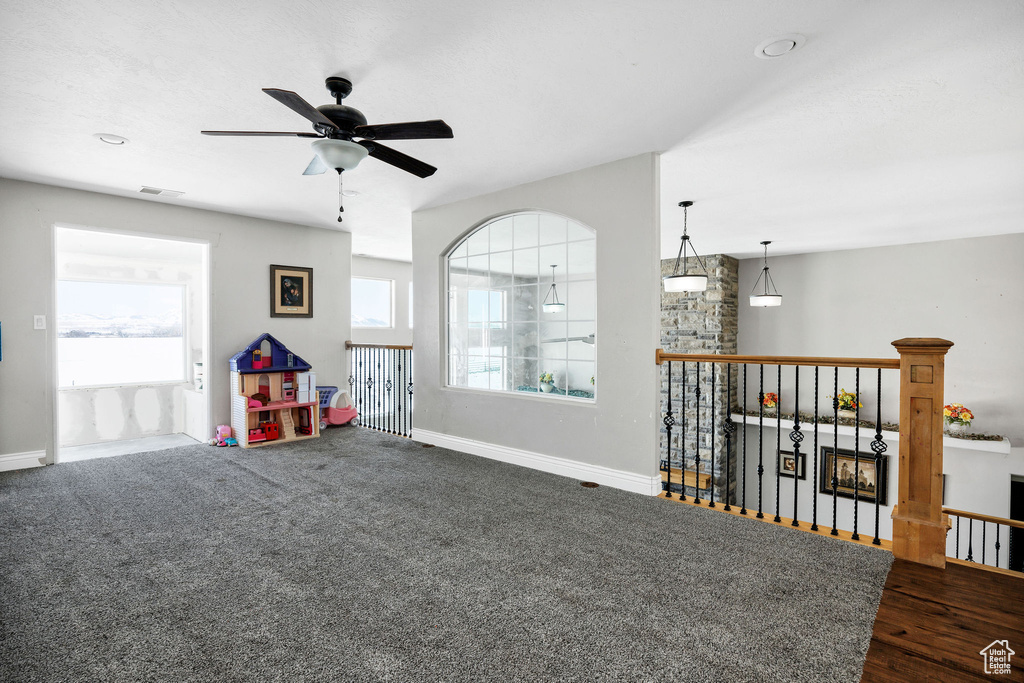 Playroom featuring a ceiling fan, visible vents, baseboards, and dark carpet