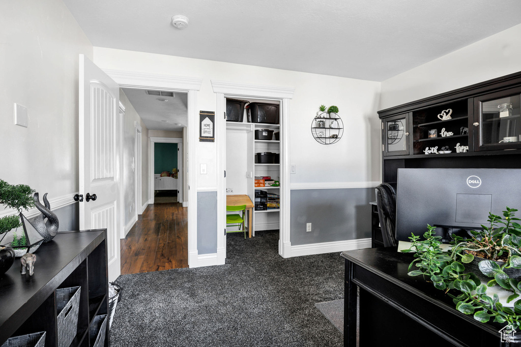 Interior space with baseboards and dark carpet