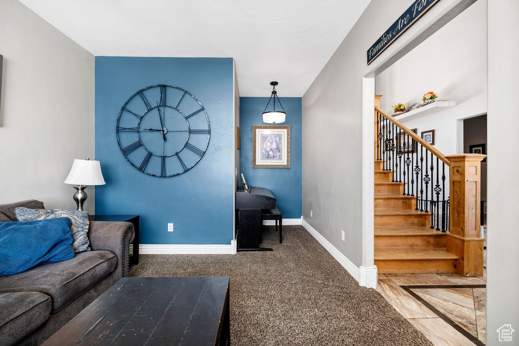 Living area featuring carpet, stairs, and baseboards