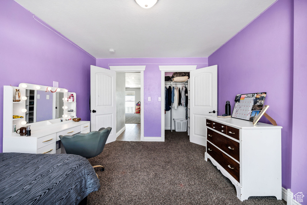 Bedroom with dark carpet and baseboards