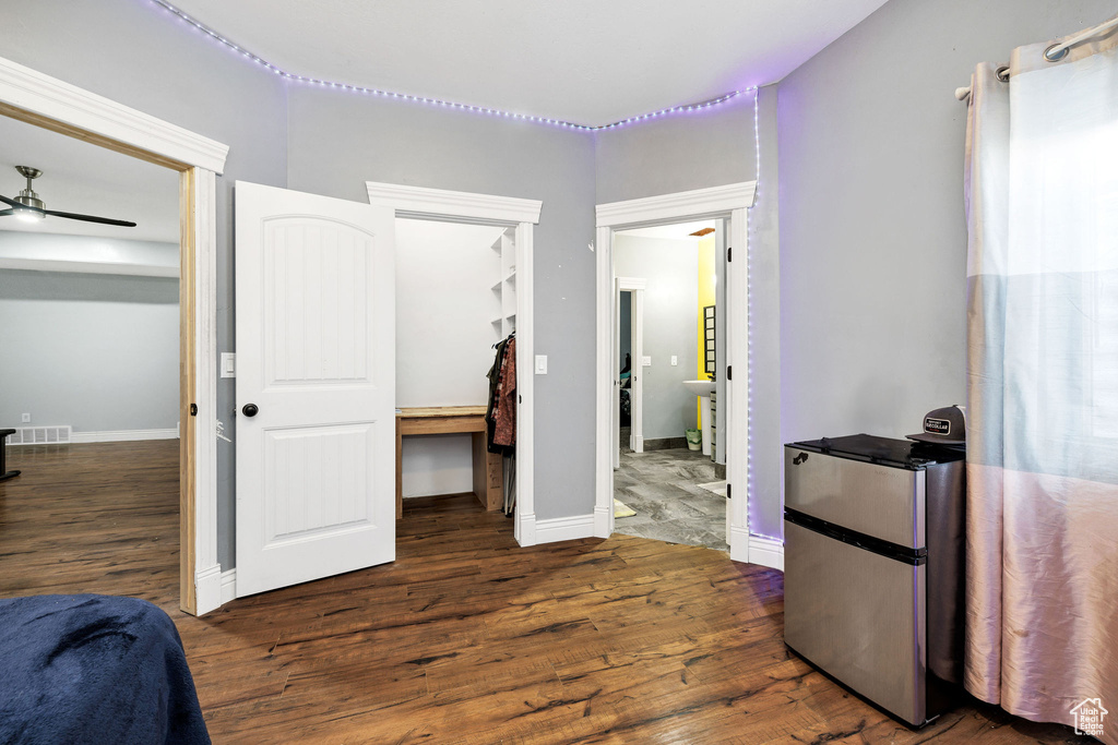 Bedroom with a closet, wood finished floors, visible vents, and freestanding refrigerator