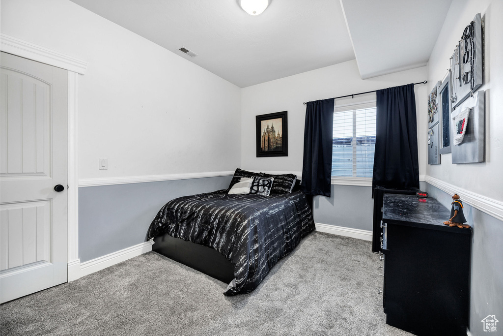 Carpeted bedroom with baseboards and visible vents