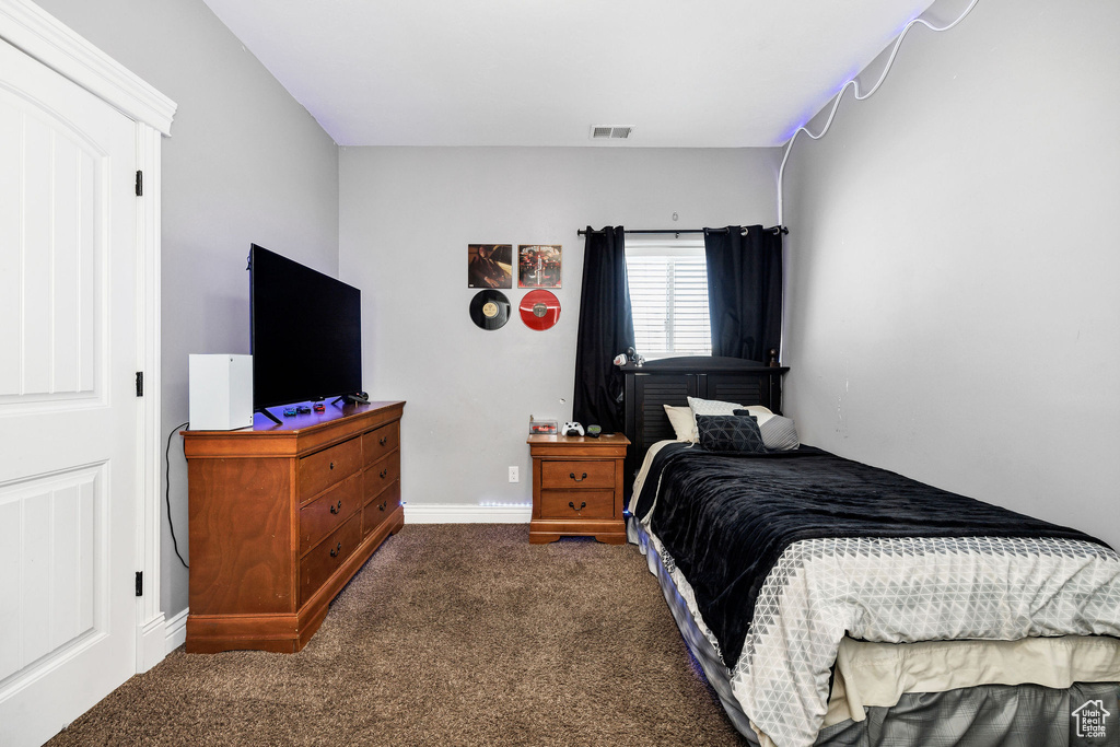 Bedroom with visible vents, carpet flooring, and baseboards