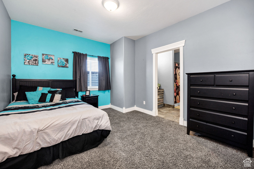 Carpeted bedroom with baseboards and visible vents