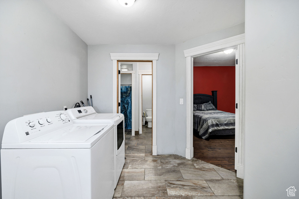 Laundry area with stone finish floor, laundry area, and washer and clothes dryer