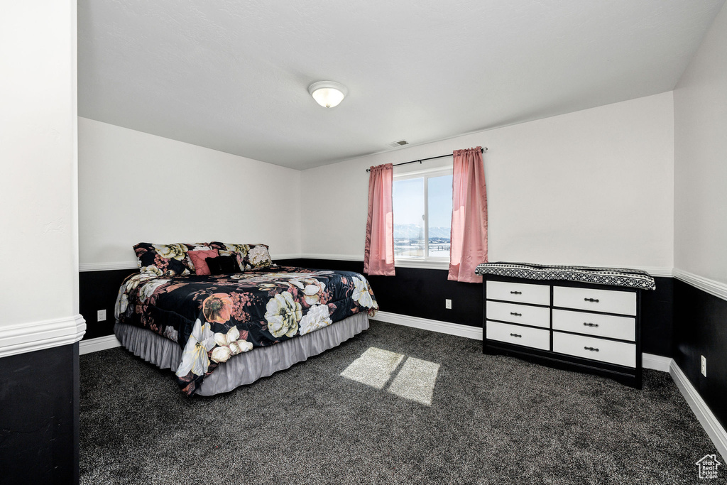 Carpeted bedroom with visible vents and baseboards