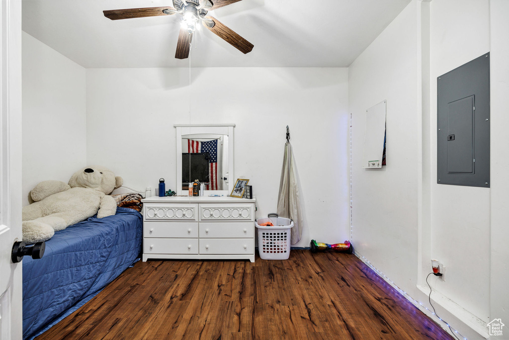 Bedroom featuring electric panel, a ceiling fan, and dark wood-style flooring