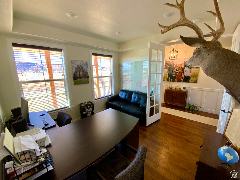 Office with dark wood-style floors and a decorative wall