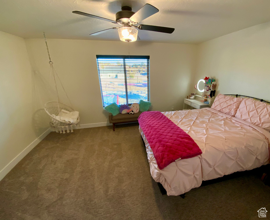 Carpeted bedroom featuring baseboards and a ceiling fan