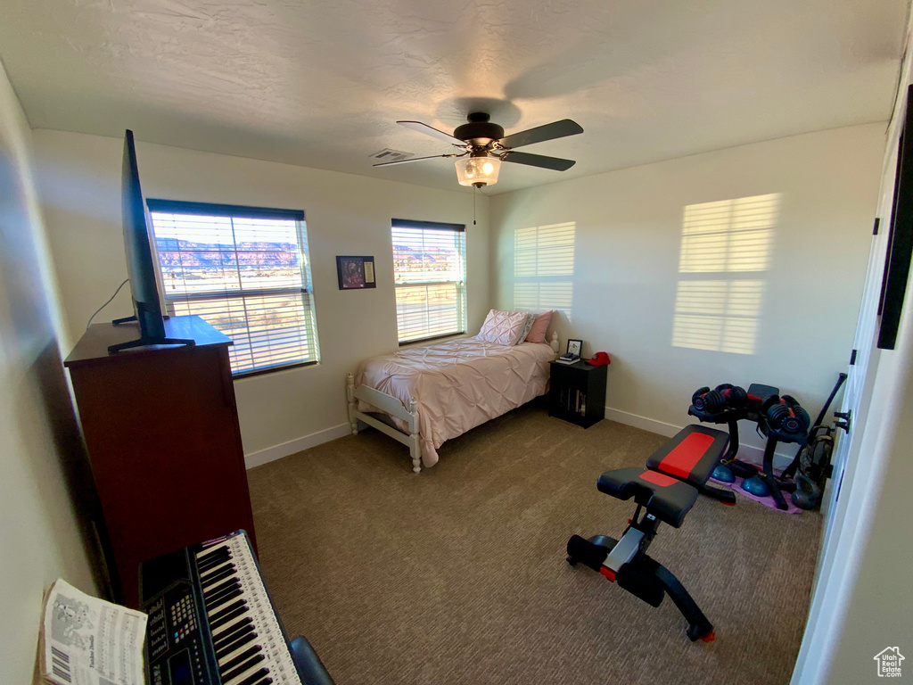 Carpeted bedroom featuring a ceiling fan, visible vents, and baseboards