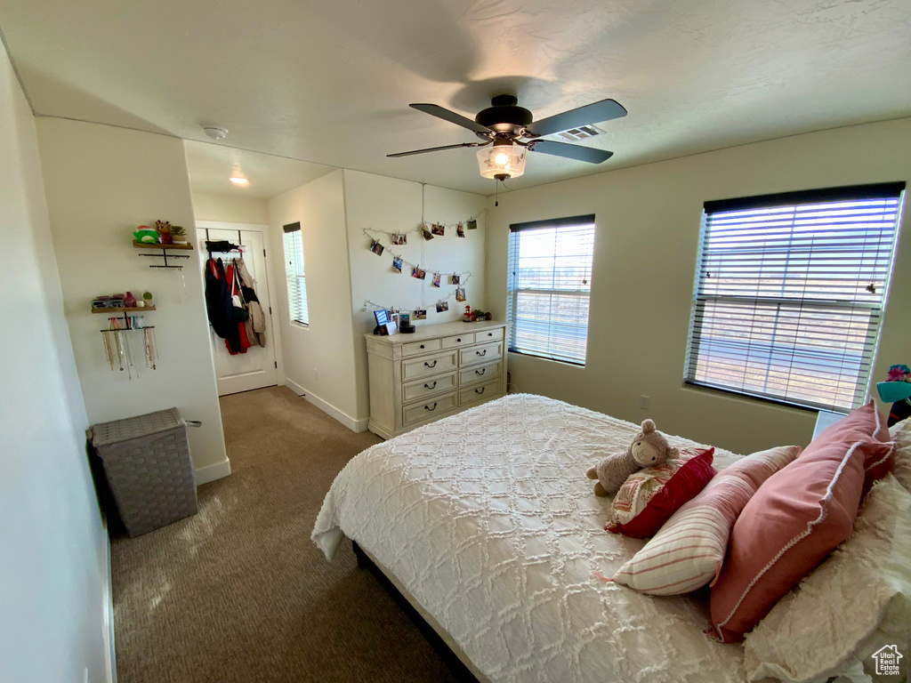 Carpeted bedroom with a ceiling fan, baseboards, and visible vents