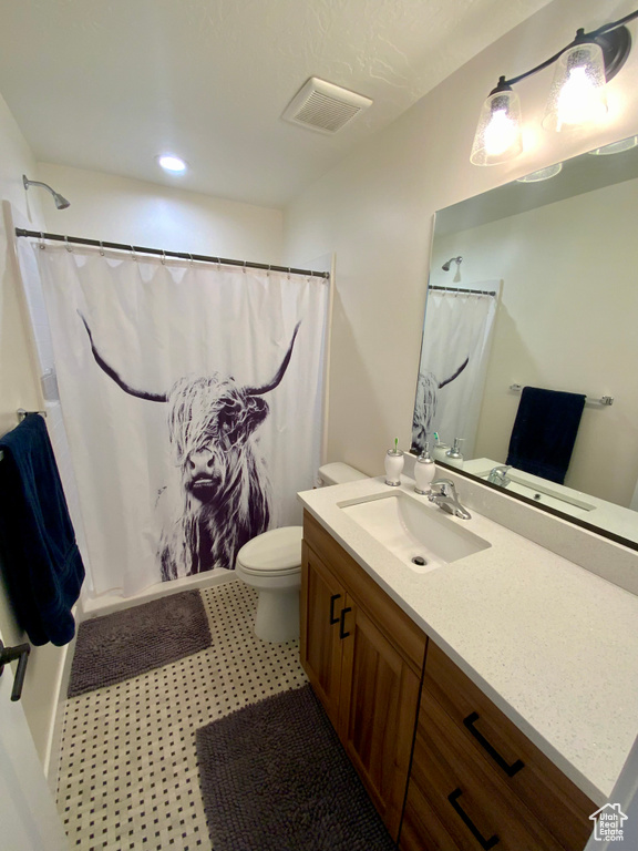 Bathroom featuring visible vents, toilet, vanity, and a shower with curtain
