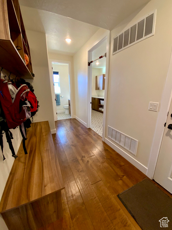 Corridor with baseboards, visible vents, and dark wood-style flooring