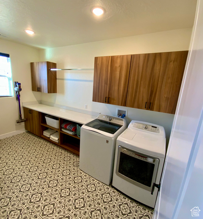 Laundry room featuring cabinet space, recessed lighting, washer and dryer, and baseboards
