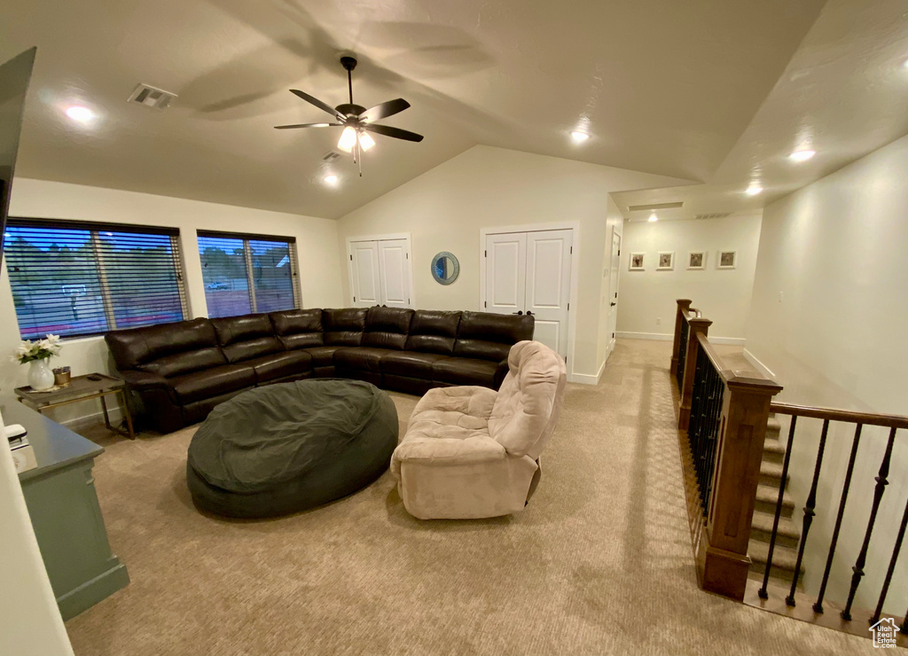 Living area with a ceiling fan, visible vents, baseboards, vaulted ceiling, and carpet flooring