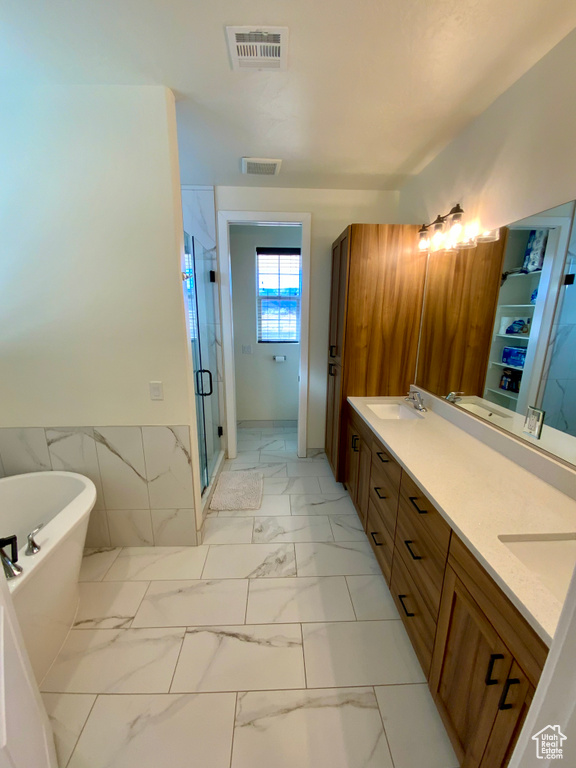 Bathroom featuring a freestanding tub, visible vents, marble finish floor, and a stall shower