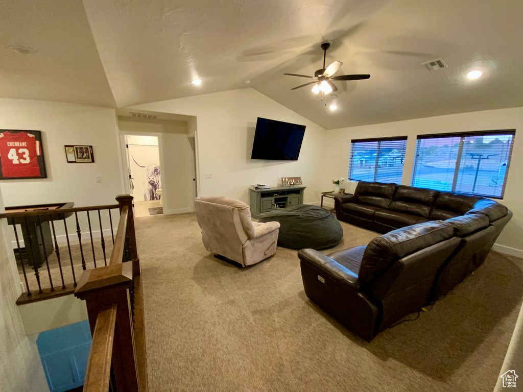 Living area with vaulted ceiling, visible vents, and light carpet