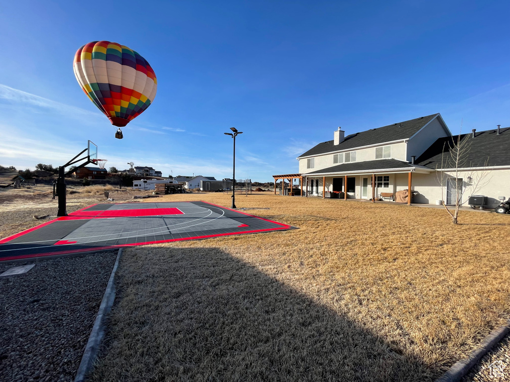 View of basketball court with community basketball court and a yard