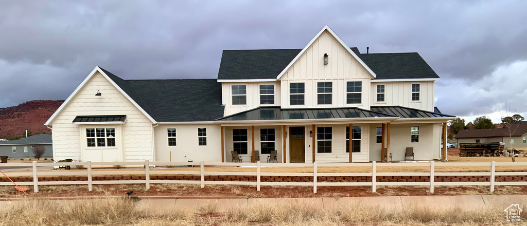 Modern farmhouse featuring board and batten siding, metal roof, a standing seam roof, and fence