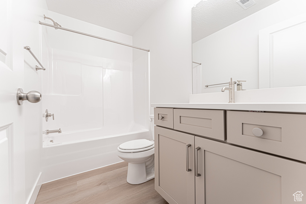 Full bath featuring wood finished floors, vanity, and tub / shower combination