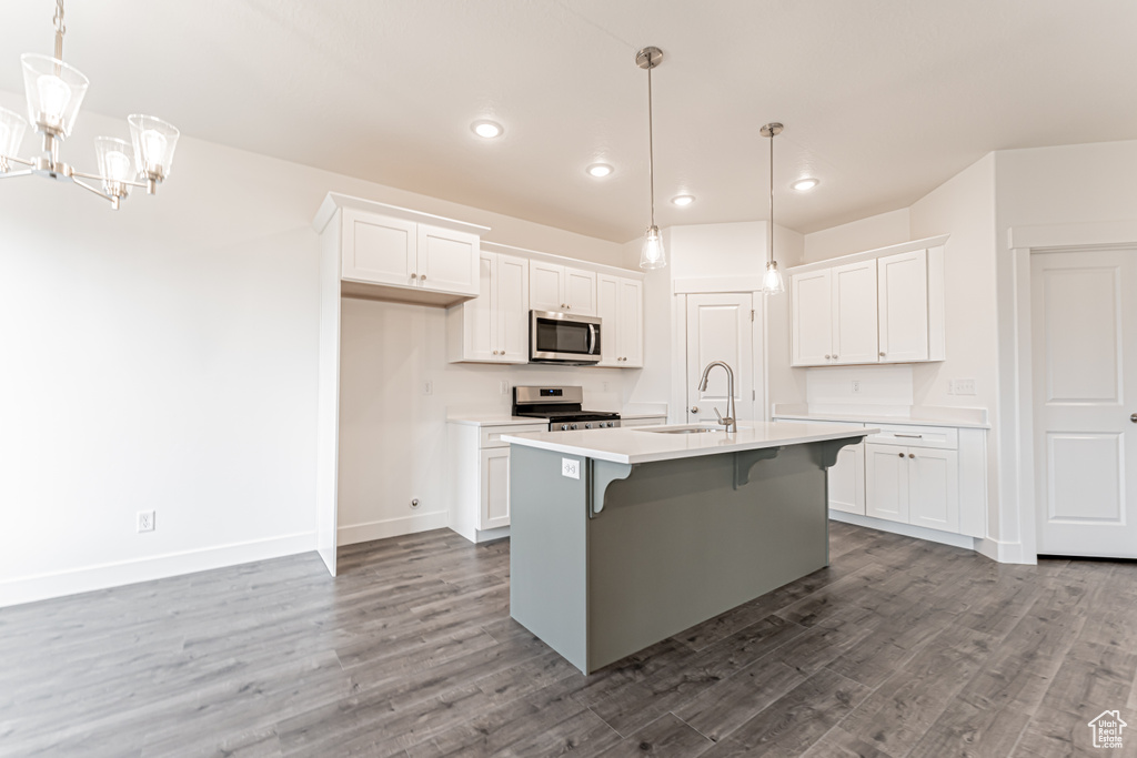 Kitchen featuring appliances with stainless steel finishes, wood finished floors, light countertops, white cabinets, and recessed lighting