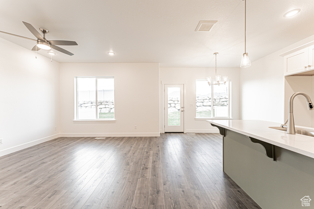 Kitchen with a breakfast bar area, healthy amount of natural light, pendant lighting, light countertops, and recessed lighting