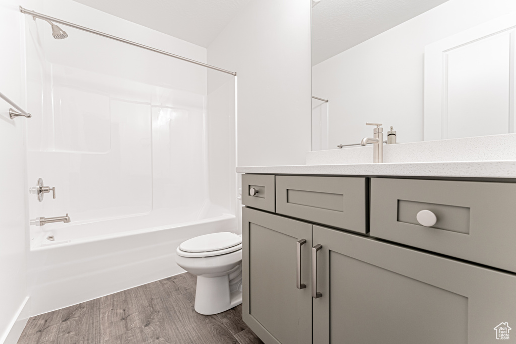 Full bath with vanity, wood finished floors, and shower / washtub combination