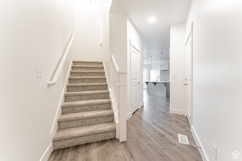 Stairs featuring wood finished floors and baseboards