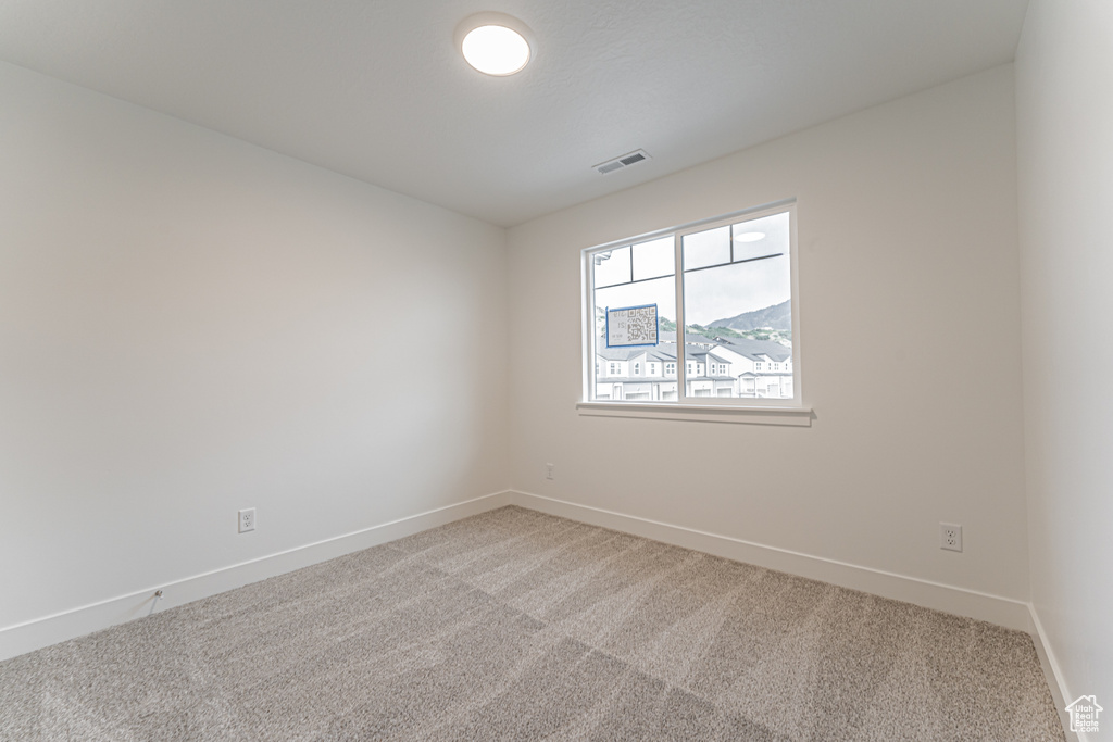 Empty room featuring light colored carpet