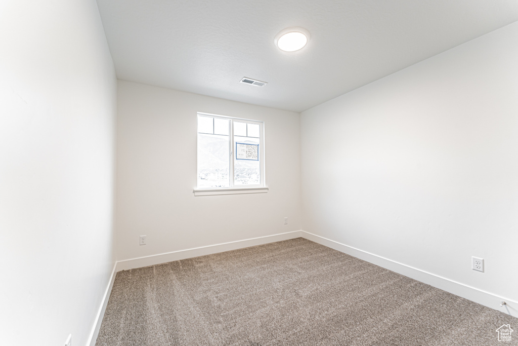 Unfurnished room featuring carpet and baseboards