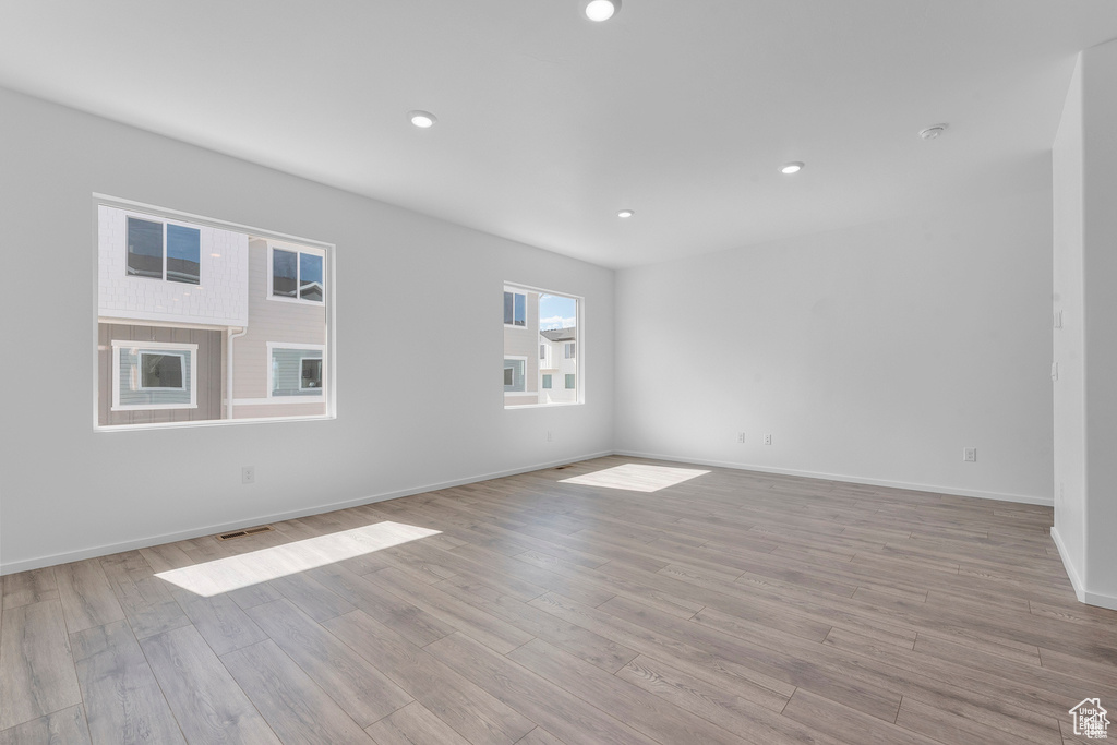 Unfurnished room featuring light wood finished floors, visible vents, recessed lighting, and baseboards