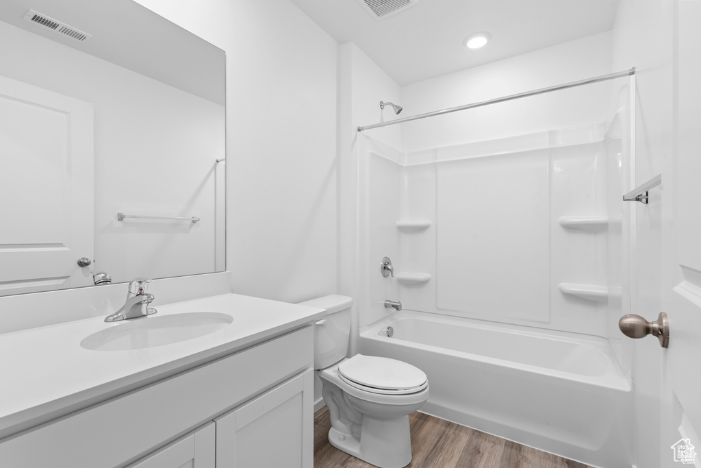 Full bathroom featuring visible vents, toilet, shower / tub combination, wood finished floors, and vanity